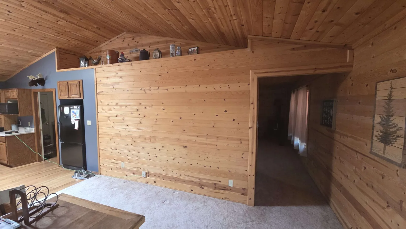 Cabin wall before: dark knotty pine and an open doorway with no door